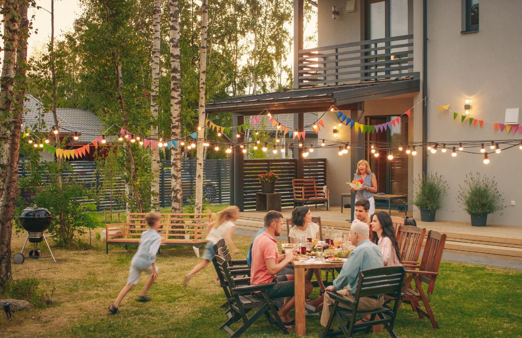 people exchanging last-minute birthday gifts at an outdoor birthday party in their garden