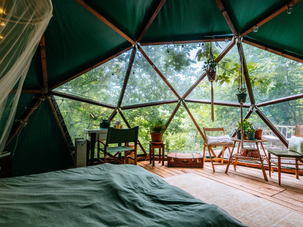 Interior de un hotel burbuja transparente con cama king-size y vistas al cielo estrellado en España