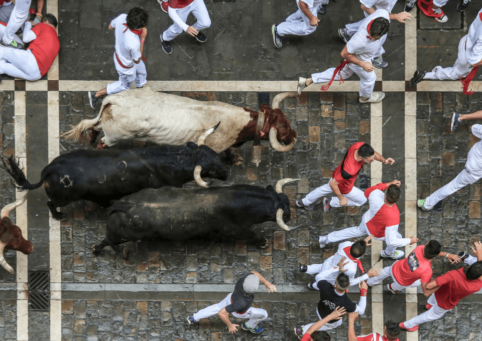 Corredores y toros en plena carrera por la calle Mayor de Pamplona durante el encierro de San Fermín 2026
